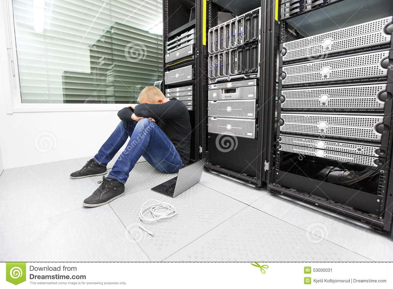 consultant-problems-datacenter-exhausted-tired-engineer-technician-sitting-leaning-against-data-racks-53000031